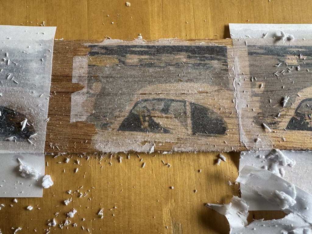 The previous four-colour image on a piece of wood with lots of the paper backing remaining.