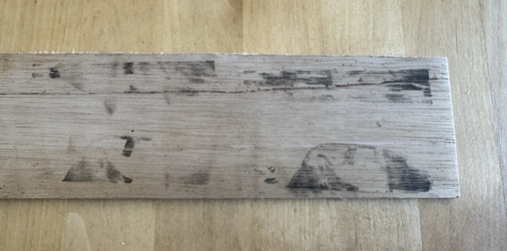 A piece of wood with black smudges that are supposed to look like the car image… but don't.