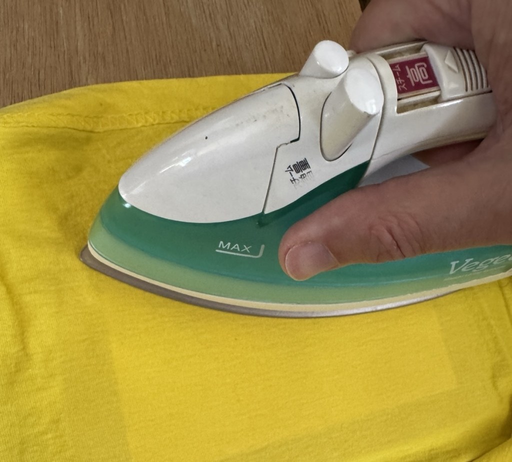 Ironing the back of the special transfer paper, with a yellow t-shirt to protect it from the heat.