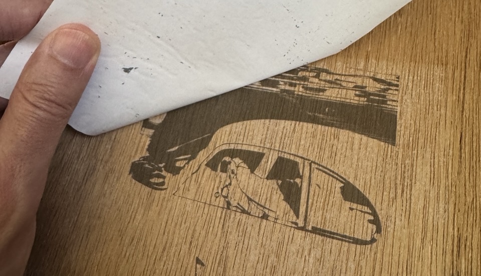 Peeling off the transfer paper to reveal a surprisingly clear black image of the car.