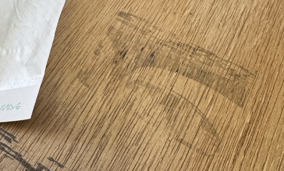 A quite faint image of the car on a piece of wood. You can just about see the outline of shapes.